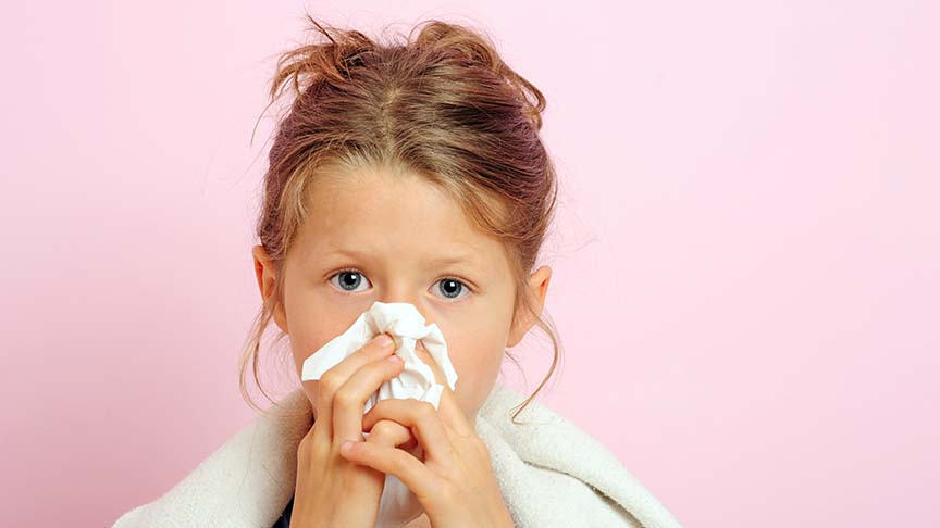 Young girl blowing nose