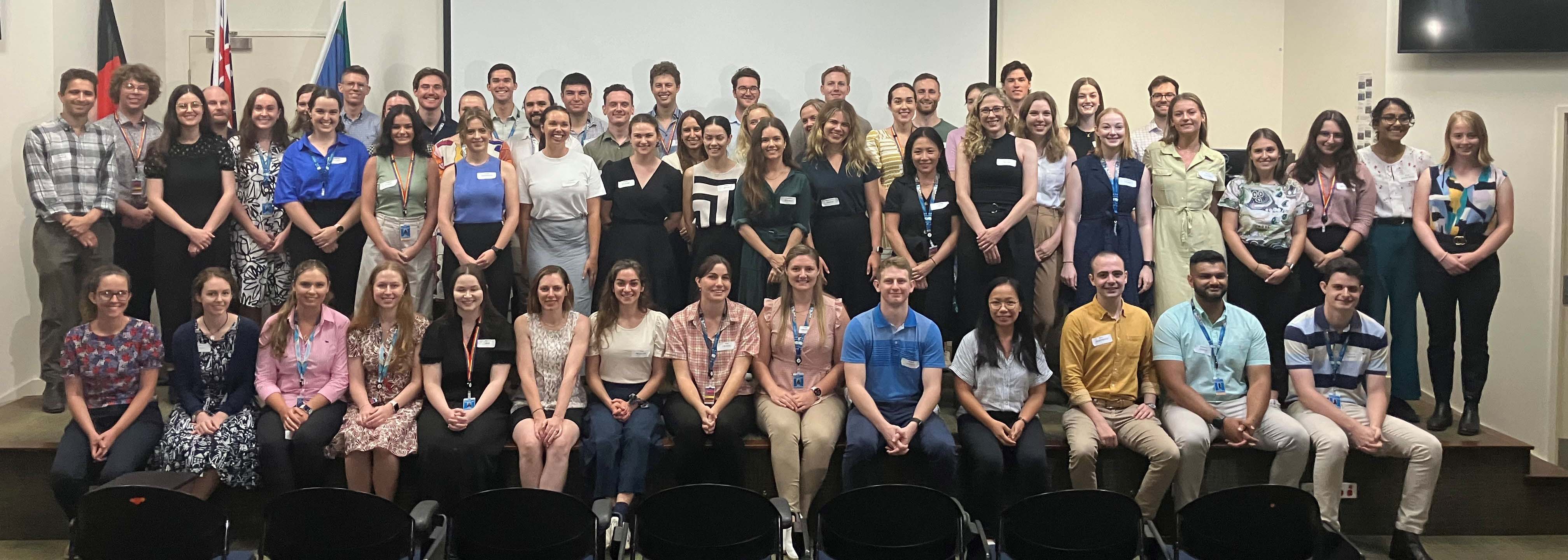 Group image of new medical interns sitting and standing on a stage