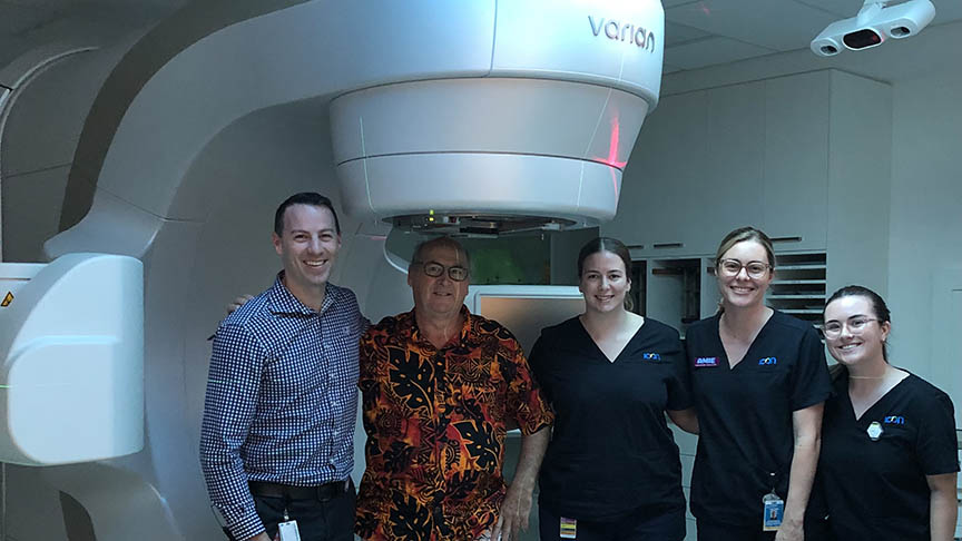 Man standing with radiography team in front of equipment